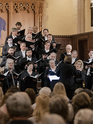members of the Santa Barbara Choral Society wearing formal attire singing